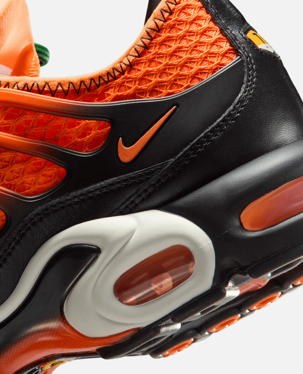 Close-up of the HOMECOMING x Nike Air Max Plus in Safety Orange featuring mesh details and visible Air unit.