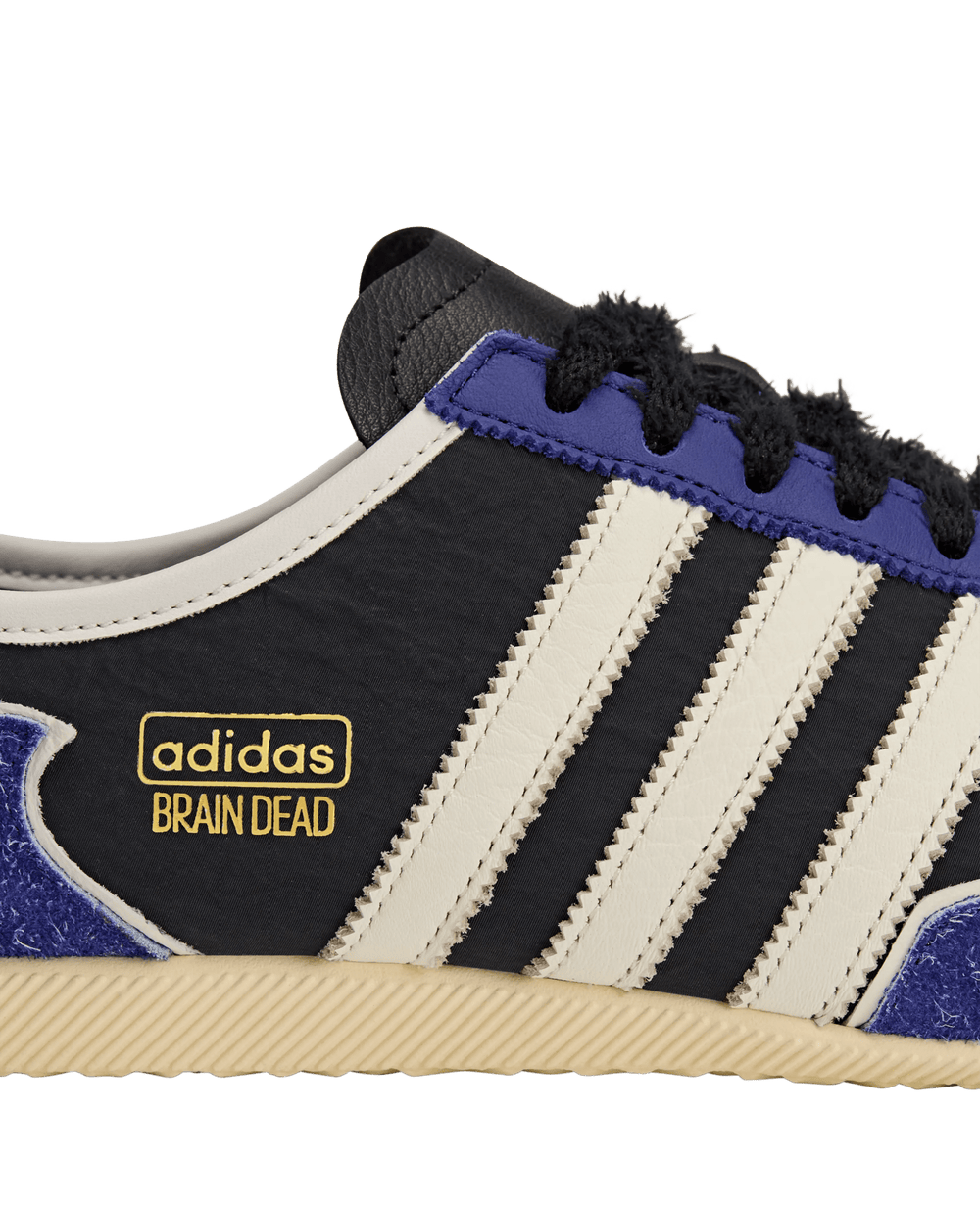 Side detail of the adidas Japan LO Brain Dead sneaker featuring white Three Stripes and gold co-branding.