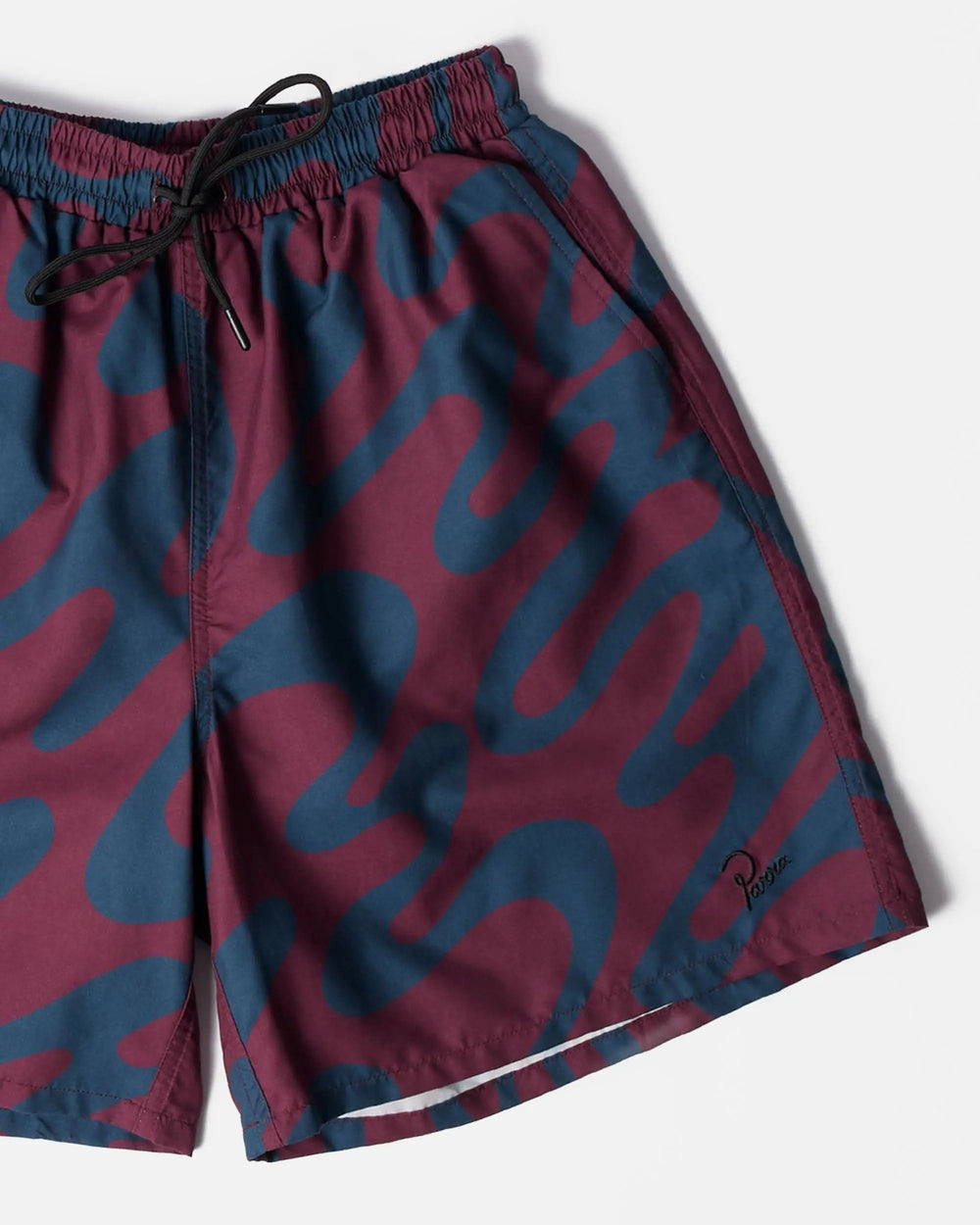 Detail of ByParra burgundy splashed swim shorts featuring an abstract blue wavy print and drawstring waist.
